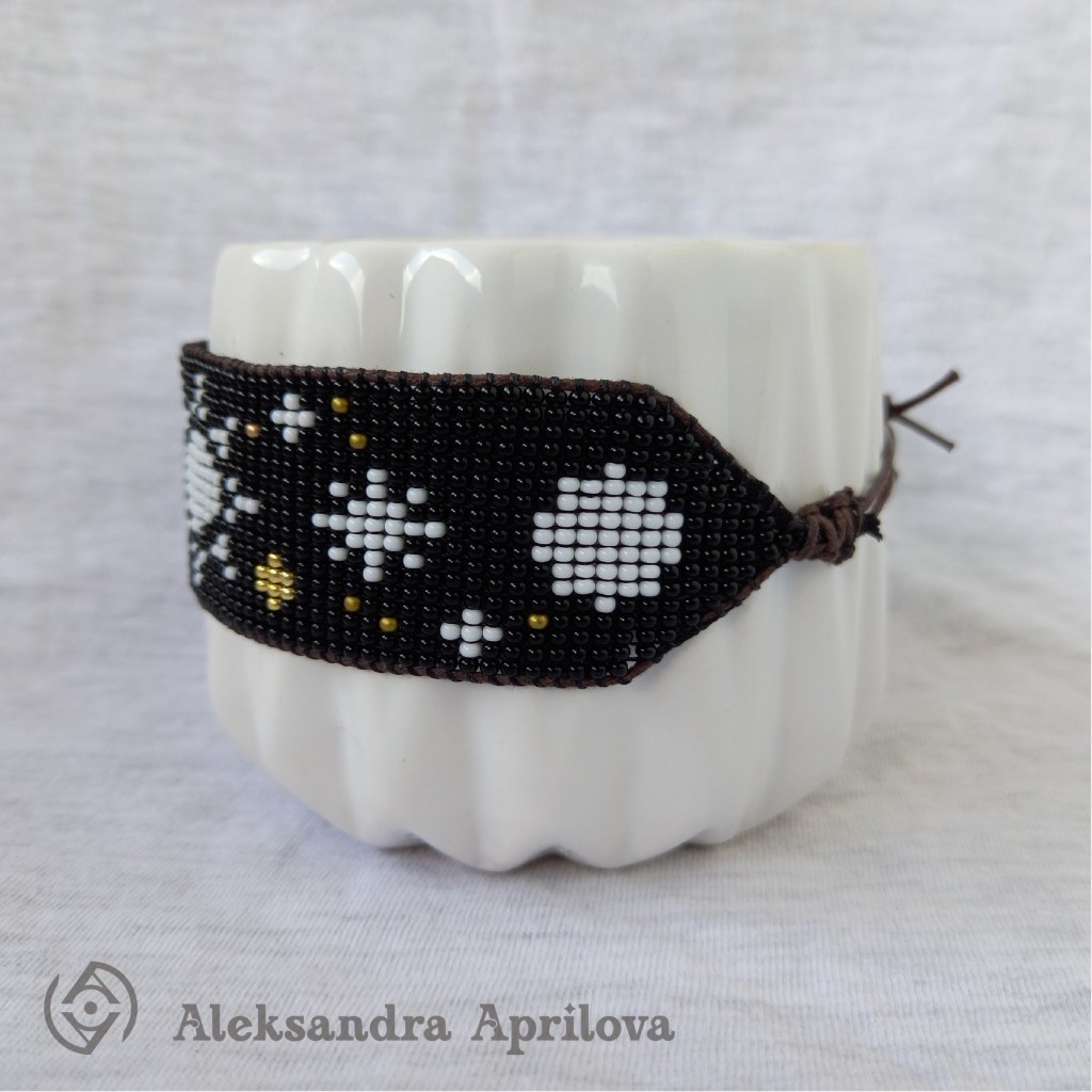 Дамска гривна от мъниста „Разходка сред звездите“ Александра Априлова. Ръчно изработена дамска гривна от мъниста с изобразени слънце, звезди и планети. Гривна за мечтателки, които обичат да се взират в необятното небе денем и нощем. Авторски дизайн. Дизайнът на гривната е вдъхновен от книгоразделителя с авторски дизайн „Сътворение“, който можете да намерите в сайта Arteism.art като можете да го комбинирате с гривна „Разходка сред звездите“ и да направите един страхотен подарък на себе си или на Ваша близка приятелка.